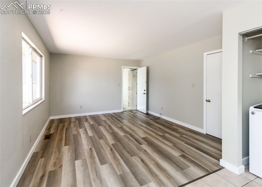 Image 24 of 48: Unfurnished bedroom with washer / dryer and light wood-style floors