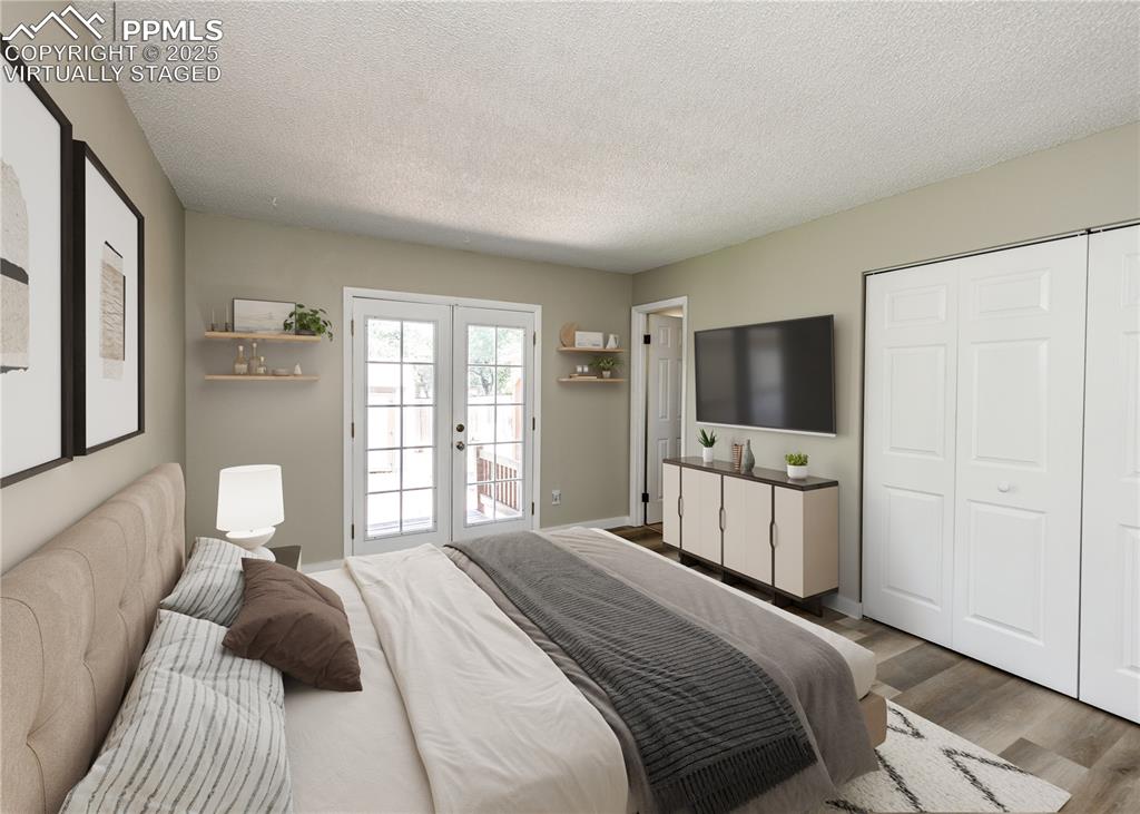 Image 29 of 48: Bedroom featuring a textured ceiling, wood finished floors, access to outsi