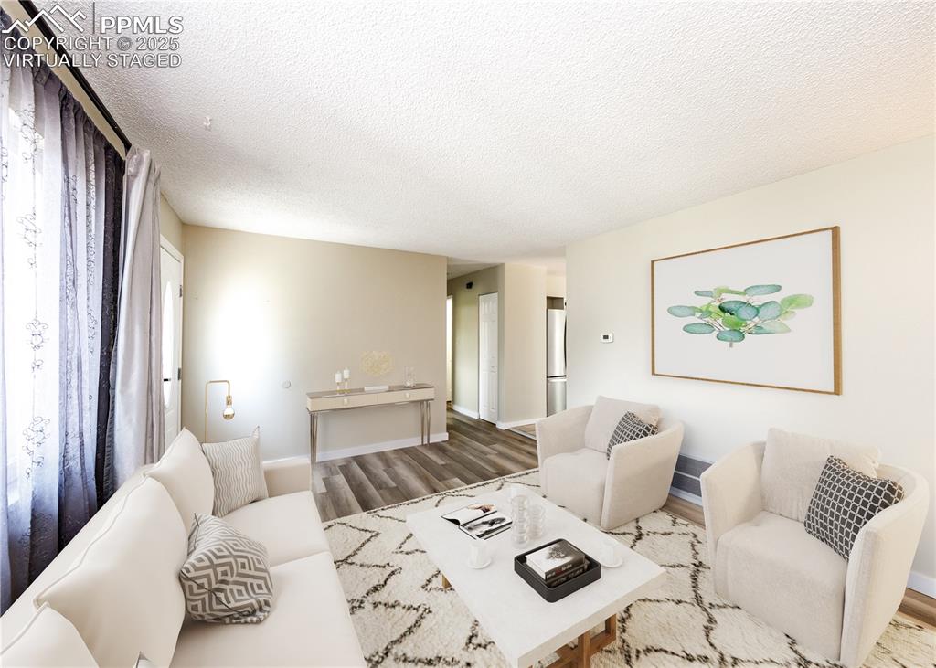 Image 7 of 48: Living room featuring a textured ceiling and wood finished floors. virtuall