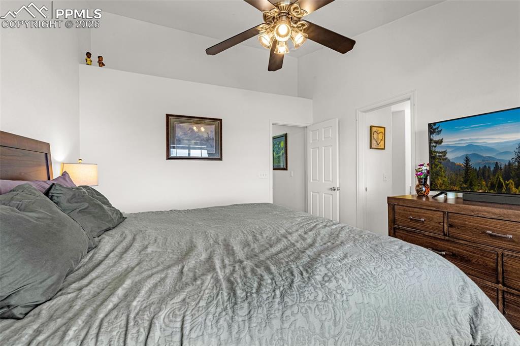 Image 13 of 29: Vaulted ceiling bedroom with a five-blade ceiling fan and recessed wall she