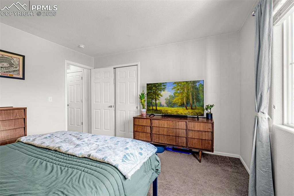 Image 18 of 29: Bedroom featuring neutral wall paint, carpeted flooring, a window with vert