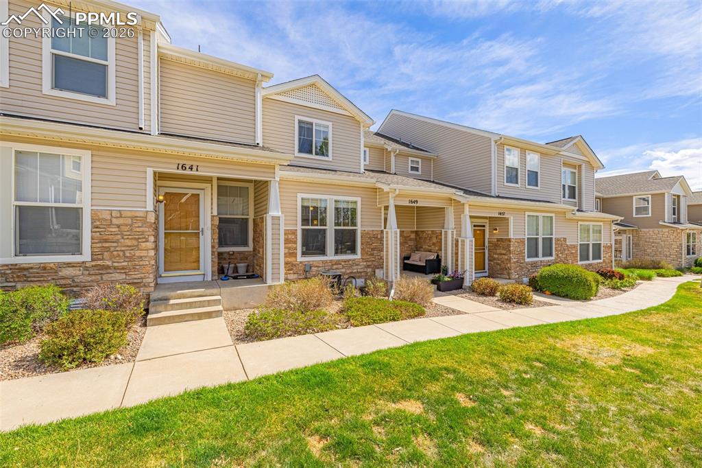 Image 27 of 29: Exterior features include light beige siding, a stone veneer facade, gabled