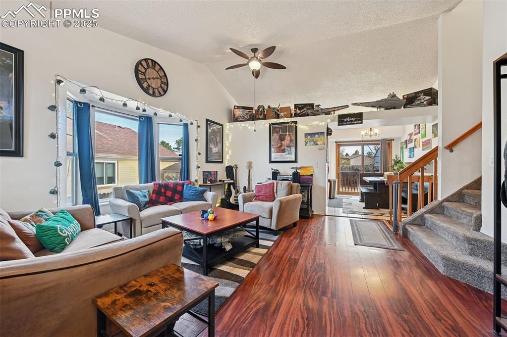 Image 6 of 27: Living room featuring wood finished floors, stairway, a textured ceiling, a