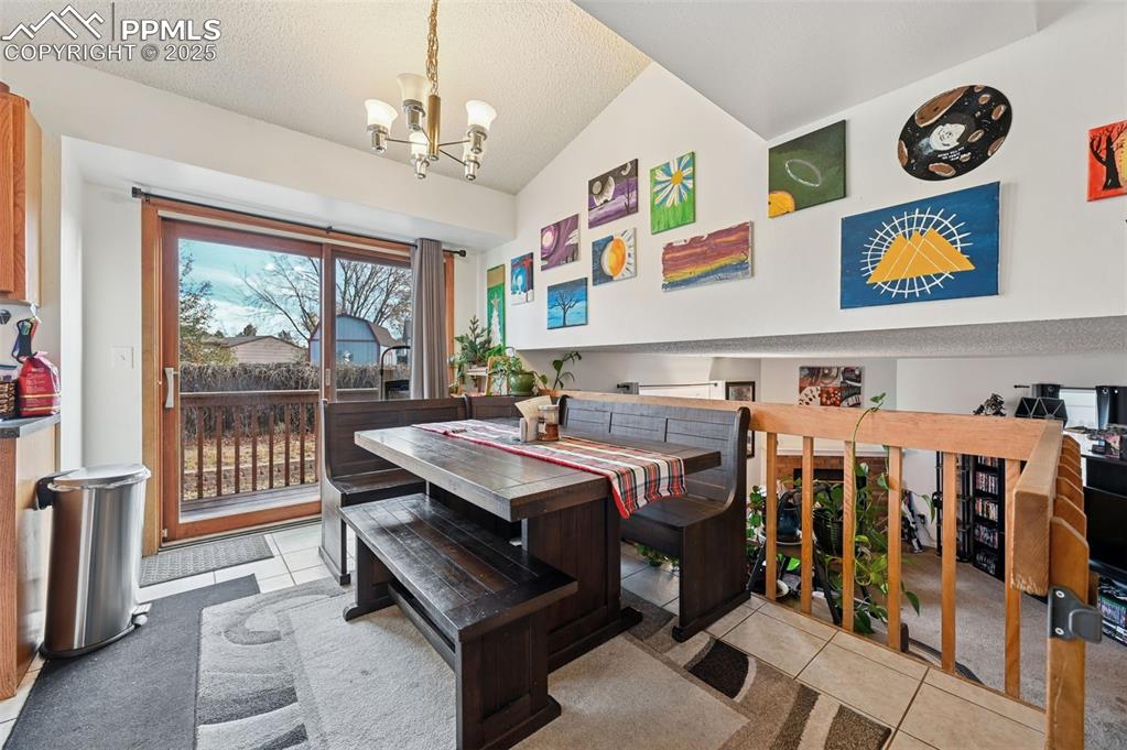 Image 7 of 27: Dining space with light tile patterned floors, a textured ceiling, light co