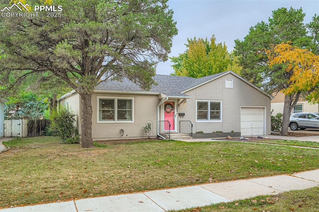Image 2 of 22: View of front of house featuring a shingled roof, stucco siding, a garage, 