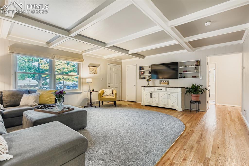 Image 6 of 22: Living area featuring beamed ceiling, coffered ceiling, and light wood-styl