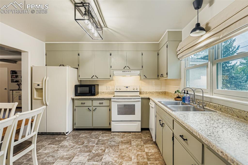 Image 8 of 22: Kitchen featuring white appliances, tasteful backsplash, under cabinet rang