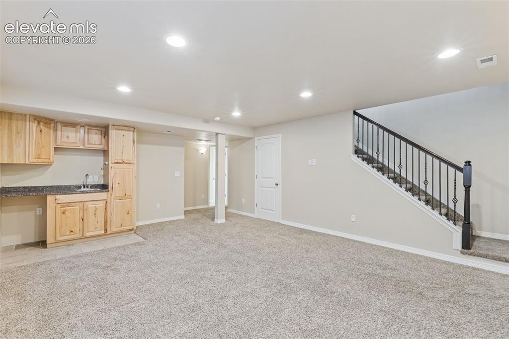 Image 29 of 46: Basement family room with wet bar.