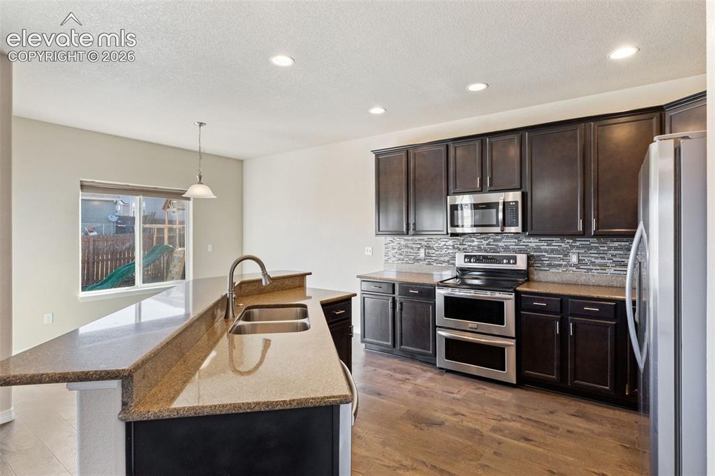 Image 9 of 46: Stainless steel appliances, double oven, and granite countertops.