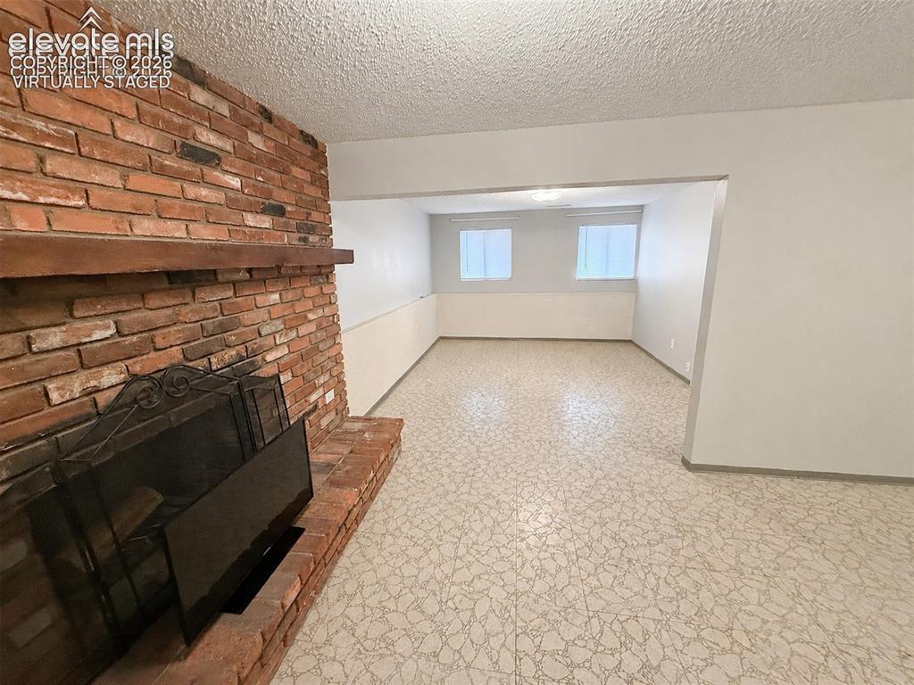 Image 10 of 27: Lowere level family room virtually staged to show it empty