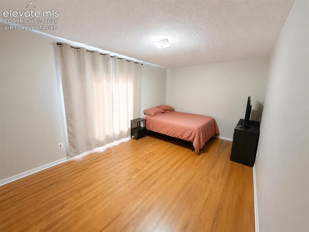 Image 18 of 27: Primary bedrrom virtually staged to show it less cluttered