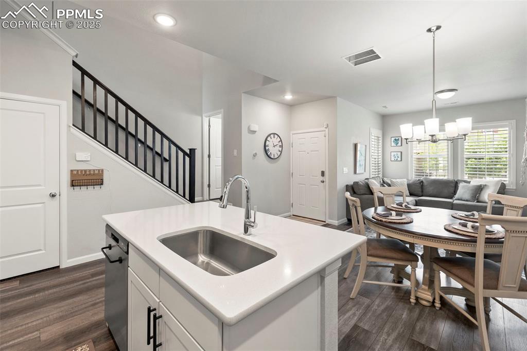 Image 10 of 24: Kitchen featuring open floor plan, dark wood finished floors, a chandelier,