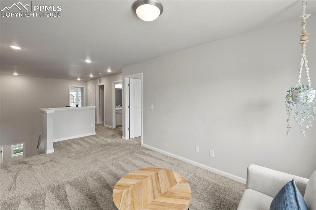 Image 13 of 24: Living area with light carpet and recessed lighting