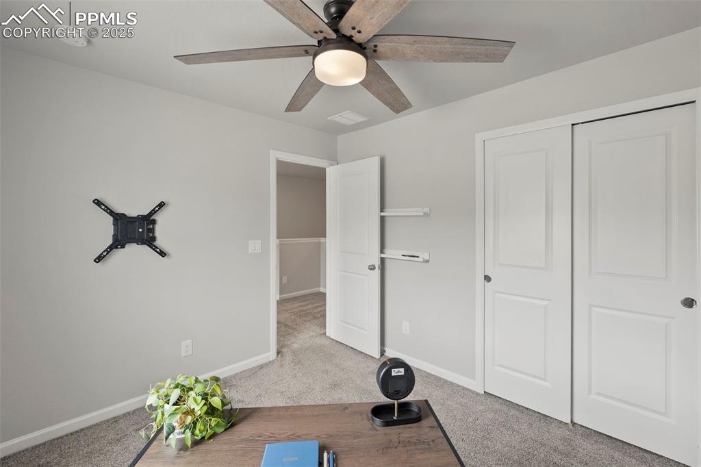 Image 17 of 24: Workout room with a ceiling fan and carpet flooring