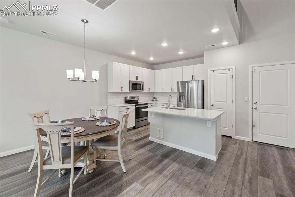 Image 2 of 24: Kitchen with stainless steel appliances, light countertops, an island with 