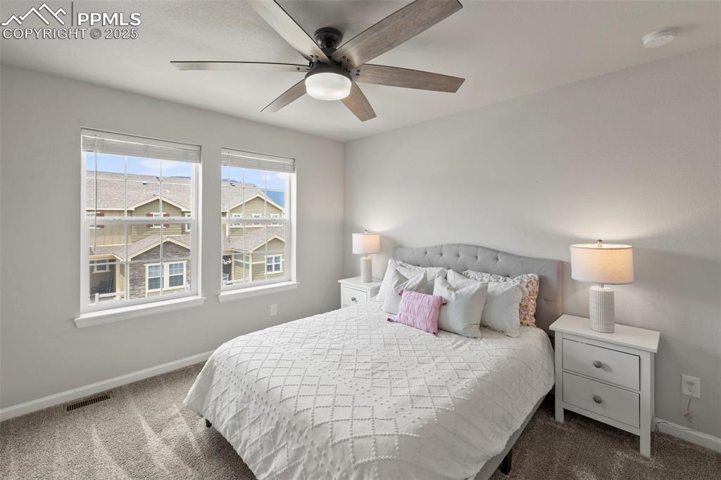 Image 20 of 24: Bedroom featuring dark carpet and ceiling fan
