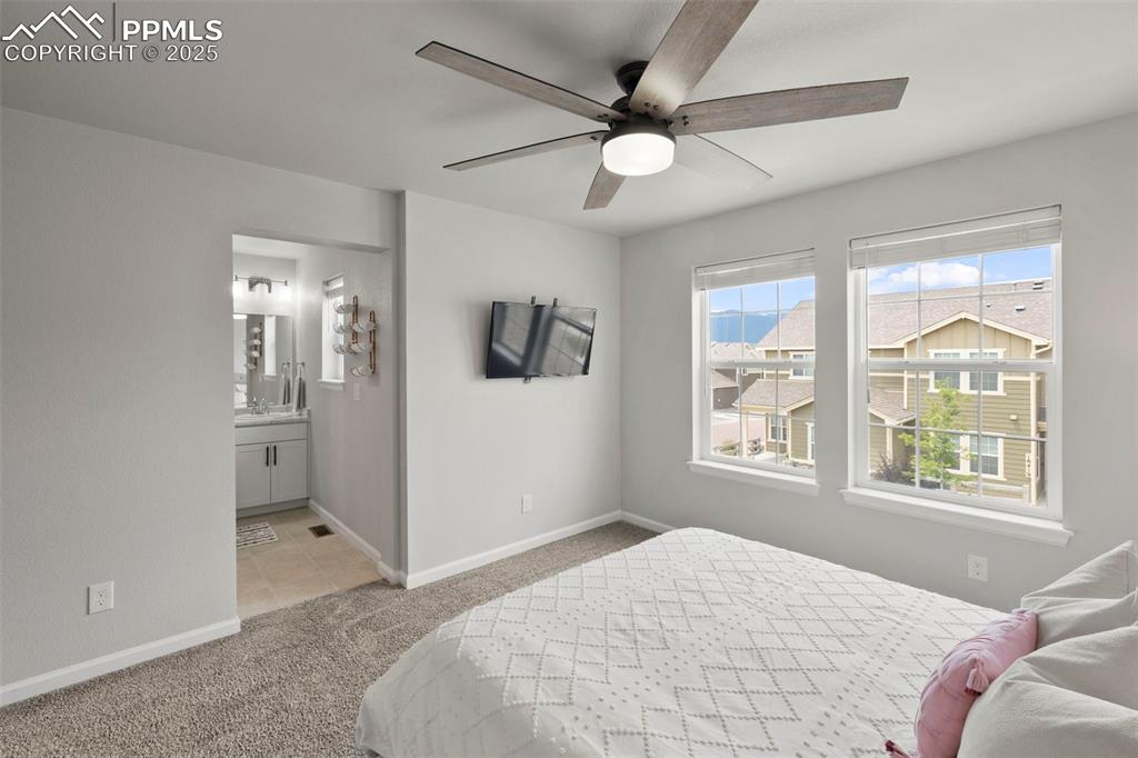 Image 21 of 24: Bedroom featuring carpet flooring, ensuite bathroom, and a ceiling fan