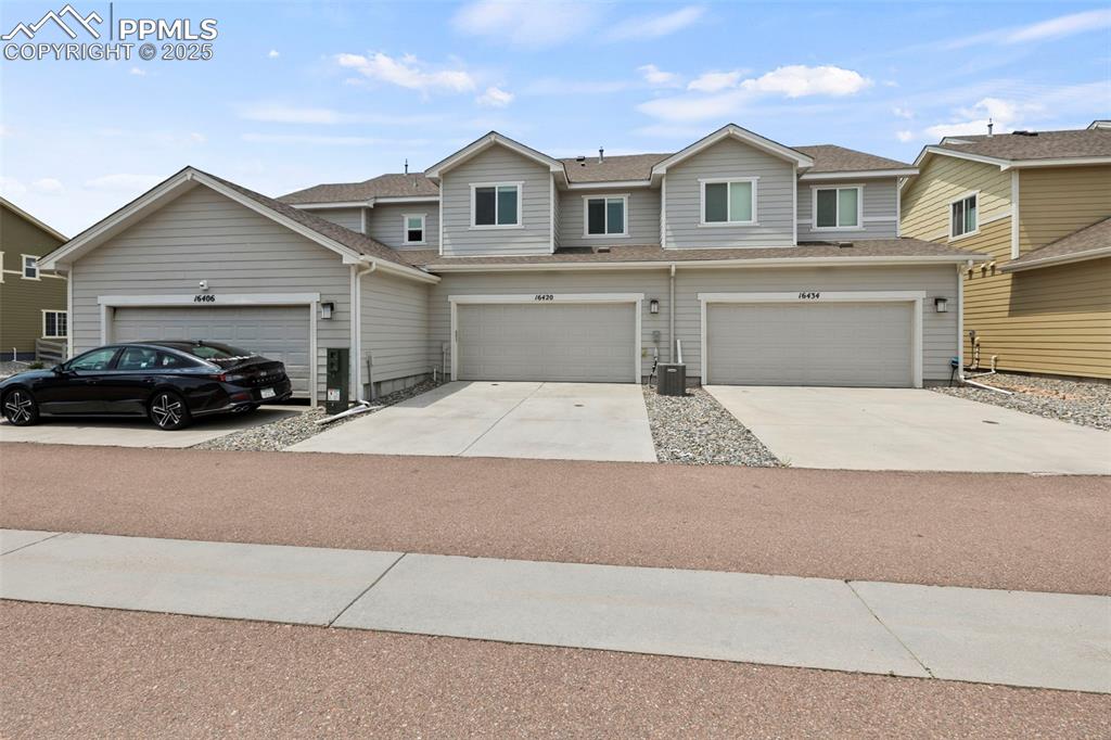 Image 24 of 24: View of front of home with roof with shingles and concrete driveway