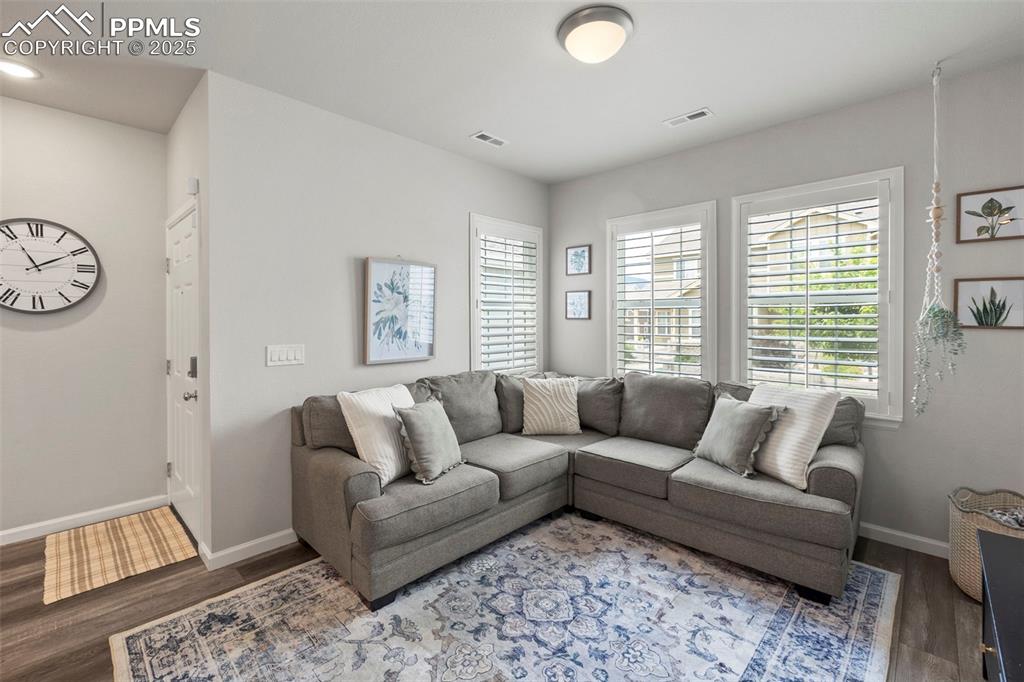 Image 4 of 24: Living room with wood finished floors and baseboards