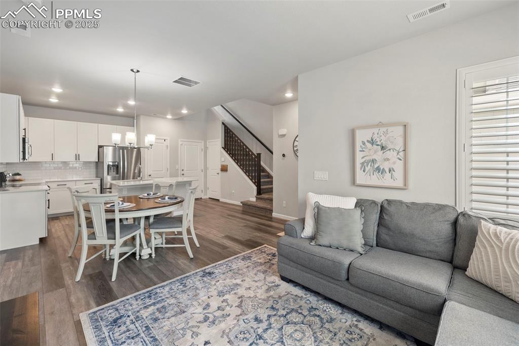 Image 5 of 24: Living area featuring dark wood-style flooring, recessed lighting, stairs, 