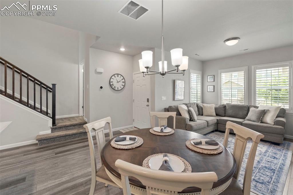 Image 7 of 24: Dining area featuring stairs, wood finished floors, a chandelier, and reces