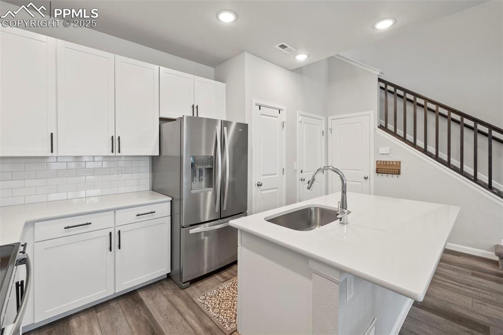 Image 9 of 24: Kitchen featuring stainless steel appliances, dark wood-style flooring, whi