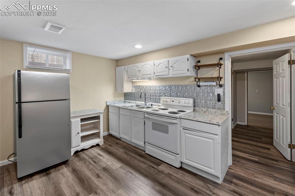 Image 16 of 30: Kitchen featuring light countertops, freestanding refrigerator, white elect