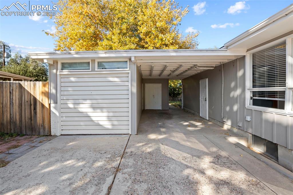 Image 21 of 30: View of parking / parking lot with driveway and an attached carport