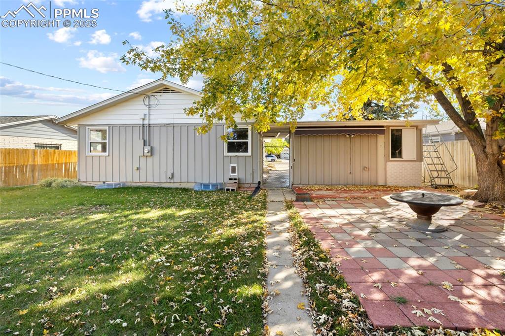 Image 25 of 30: Back of property featuring board and batten siding, a fire pit, and crawl s