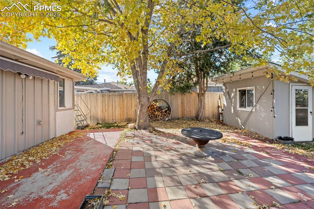 Image 27 of 30: Fenced backyard with a patio area