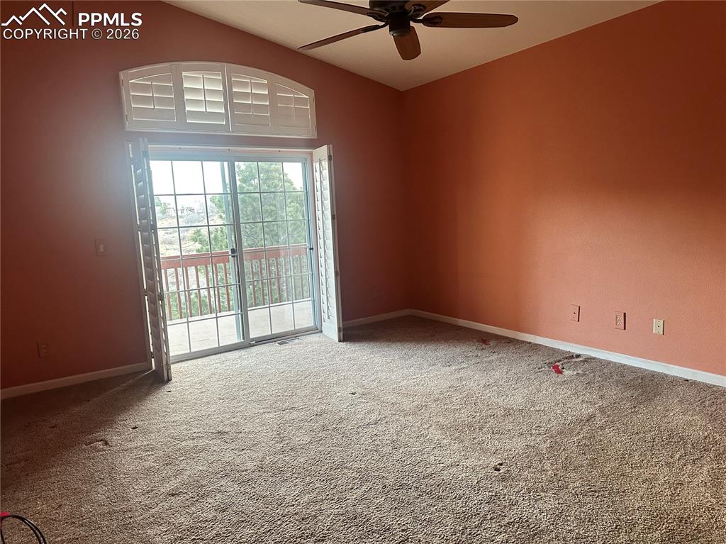 Image 18 of 39: Primary bedroom has plantation shutters and a sliding glass door to the dec