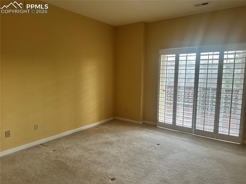 Image 31 of 39: Basement bedroom with slider out to deck