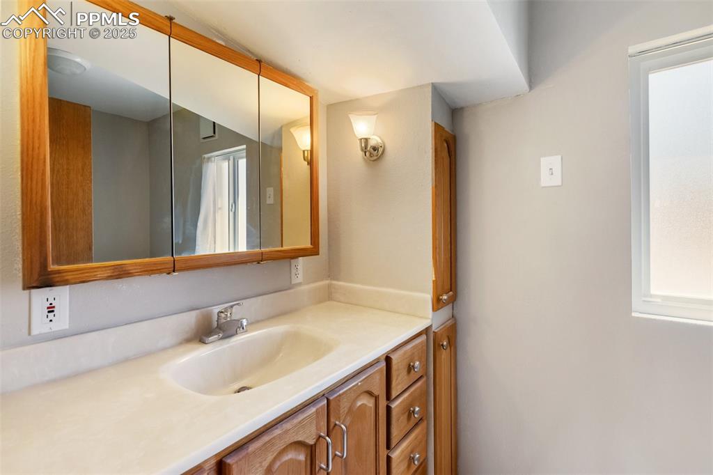 Image 26 of 36: Main bath, a 3/4 super sink cabinets and mirror this bath is south of the k