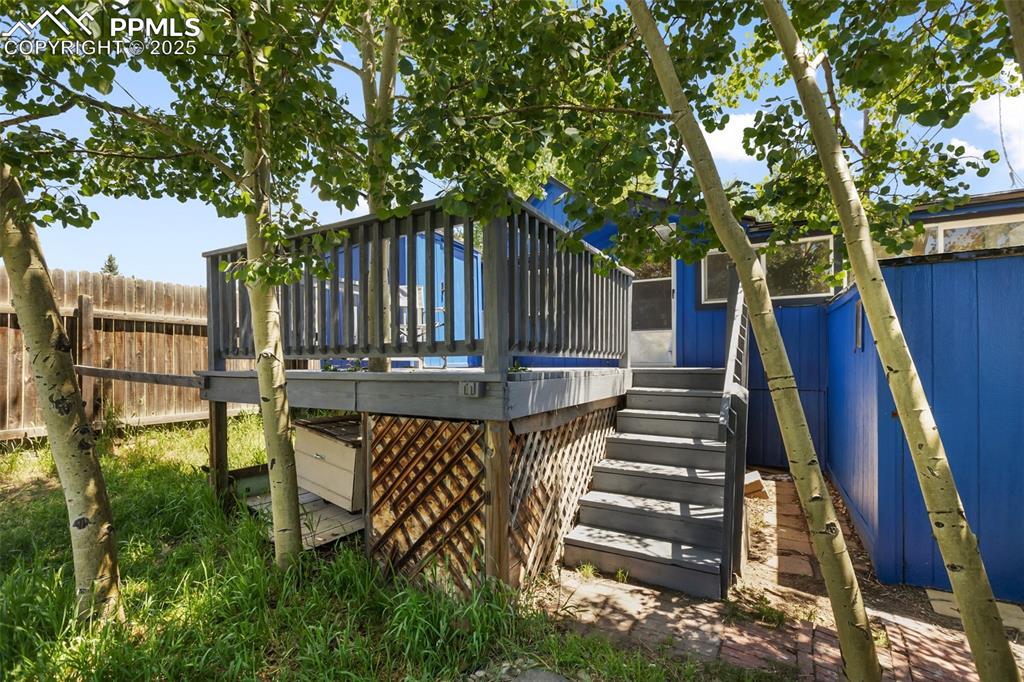 Image 7 of 36: The deck and stair case looking east from the back yard. There is another s