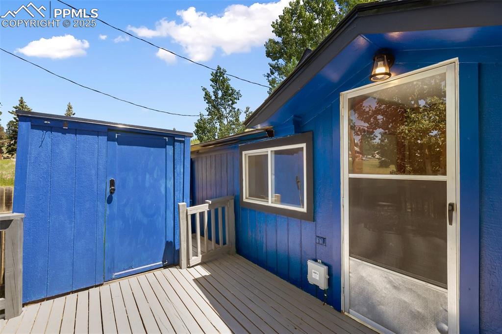 Image 9 of 36: from the deck looking north east at the rear door and one of the storage sh