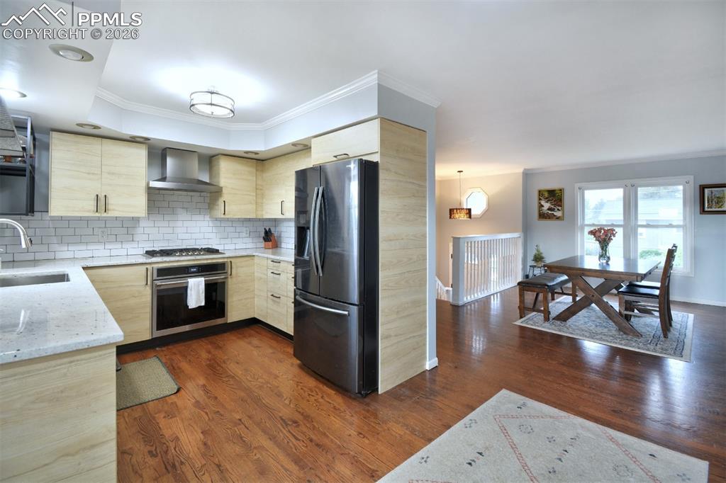 Image 4 of 27: Newly renovated kitchen with wood flooring and SS appliances.