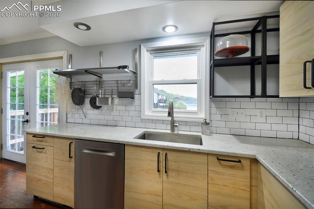 Image 9 of 27: Granite counters, farm sink and open shelving accents.