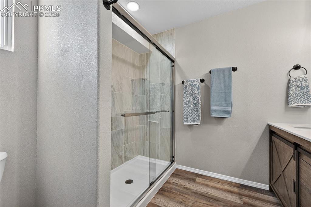 Image 26 of 50: Glass shower doors and custom tile in the large shower.