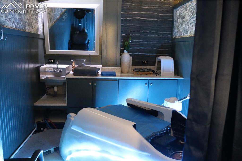 Image 4 of 5: Office with a sink and wallpapered walls