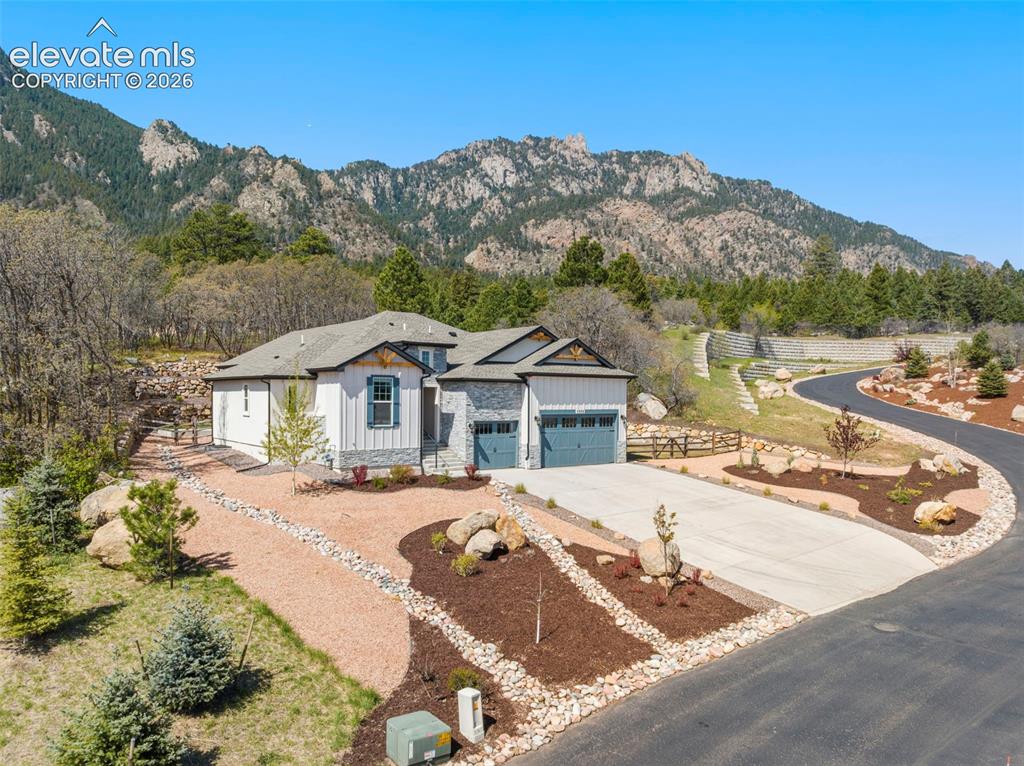 Image 1 of 47: Contemporary mountain home featuring a stone and siding exterior, a two-car