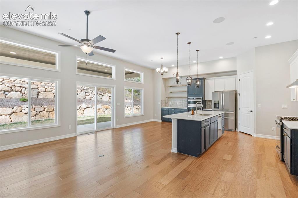 Image 12 of 47: Spacious open-concept living area featuring wood-finish flooring, a contemp