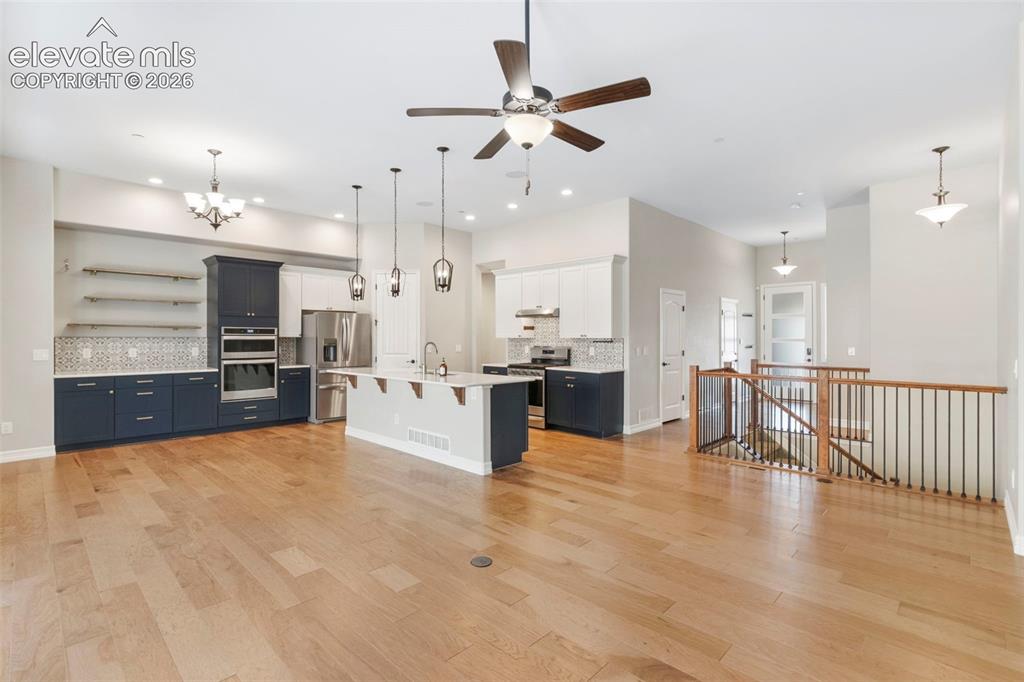 Image 13 of 47: Open-concept living area featuring light wood-finish flooring, a contempora