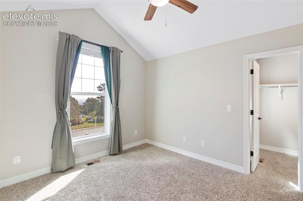 Image 19 of 47: Vaulted ceiling room featuring a large multi-pane window, neutral-toned car