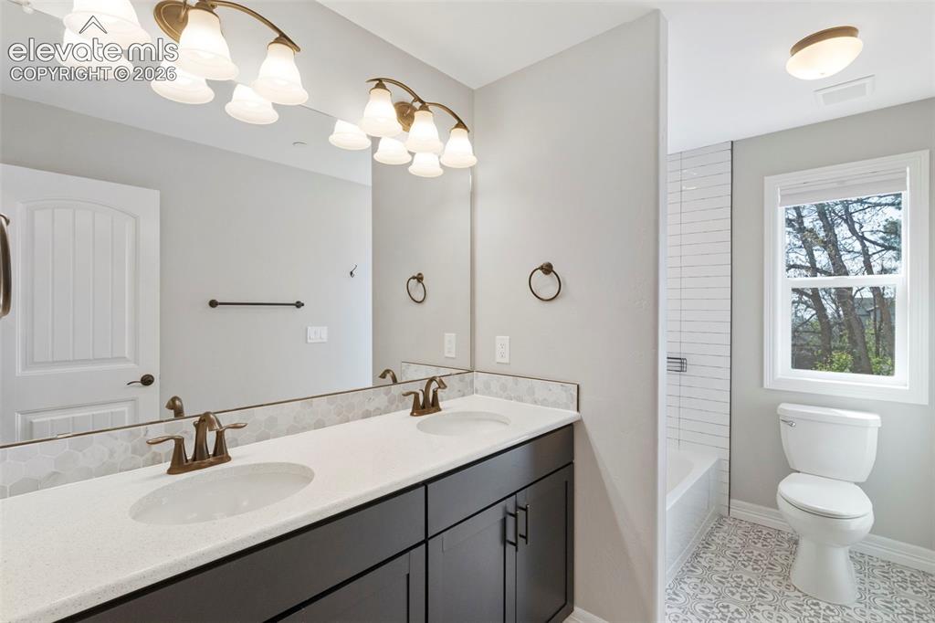 Image 22 of 47: Double vanity with white solid surface countertops and integrated sinks