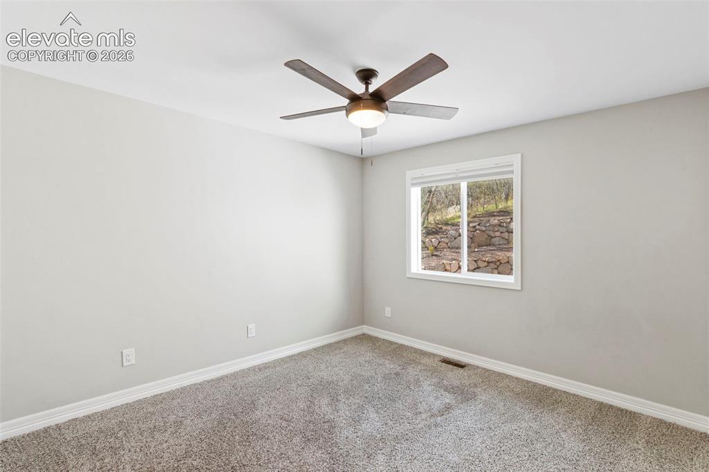Image 31 of 47: Bedroom featuring light gray wall paint, gray carpet flooring, white trim, 