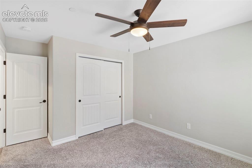 Image 32 of 47: Bedroom featuring light grey walls, plush grey carpeting, a ceiling fan wit