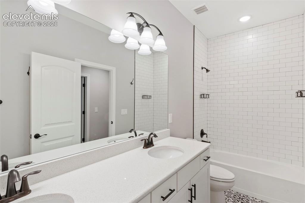 Image 33 of 47: Bathroom featuring a dual vanity with undermount sinks and a light-toned co