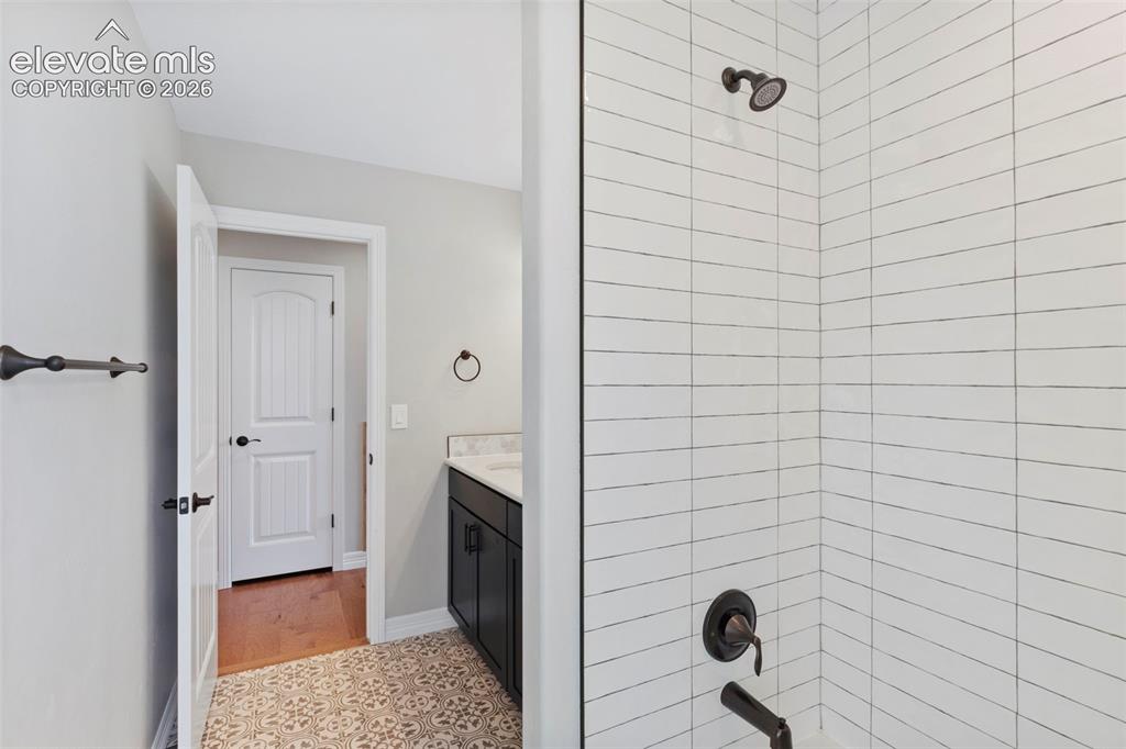 Image 34 of 47: Shower with white subway tile surround and dark bronze fixtures, complement