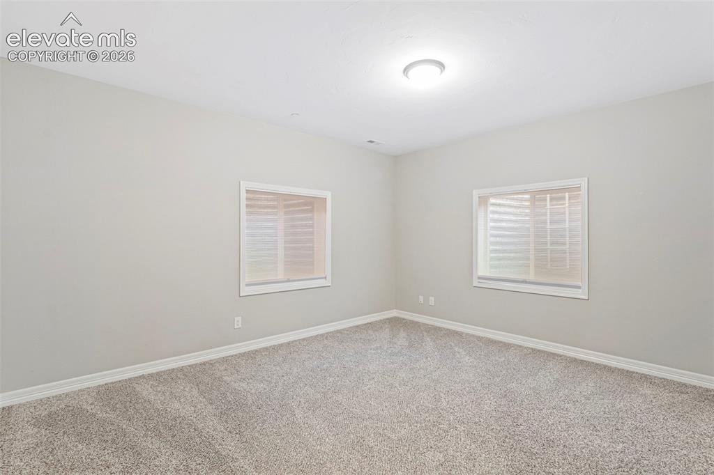 Image 35 of 47: Neutral-toned room featuring light gray walls, plush gray carpet, white bas