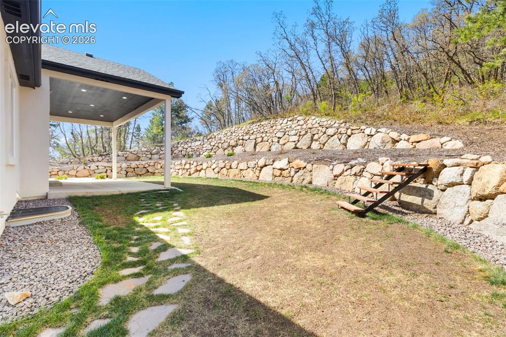 Image 40 of 47: Covered concrete patio with recessed lighting